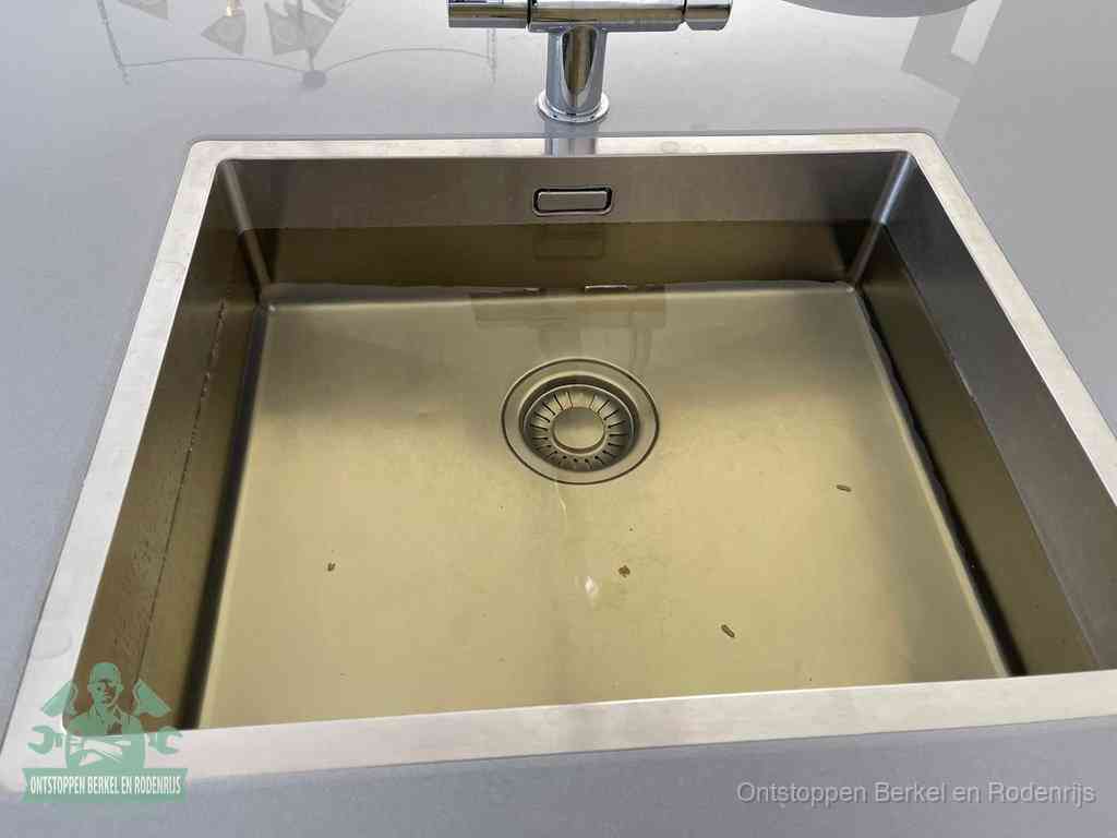 Een RVS spoelbak met stilstaand water dat niet wegloopt, een van de eerste signalen van een beginnende verstopping in Berkel en Rodenrijs