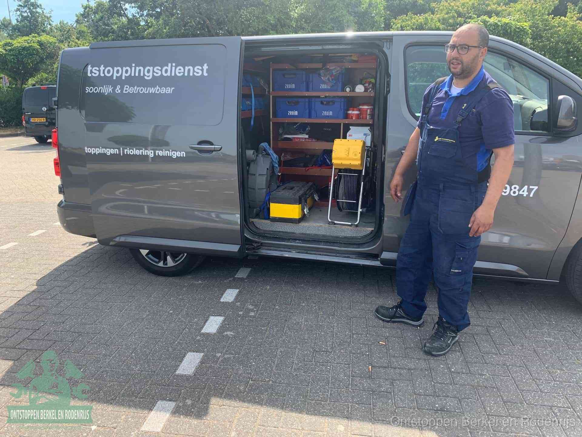 Een monteur staat klaar bij zijn bedrijfsbus met gereedschap, de vaste werkwijze van de ontstoppingsdienst in Berkel en Rodenrijs